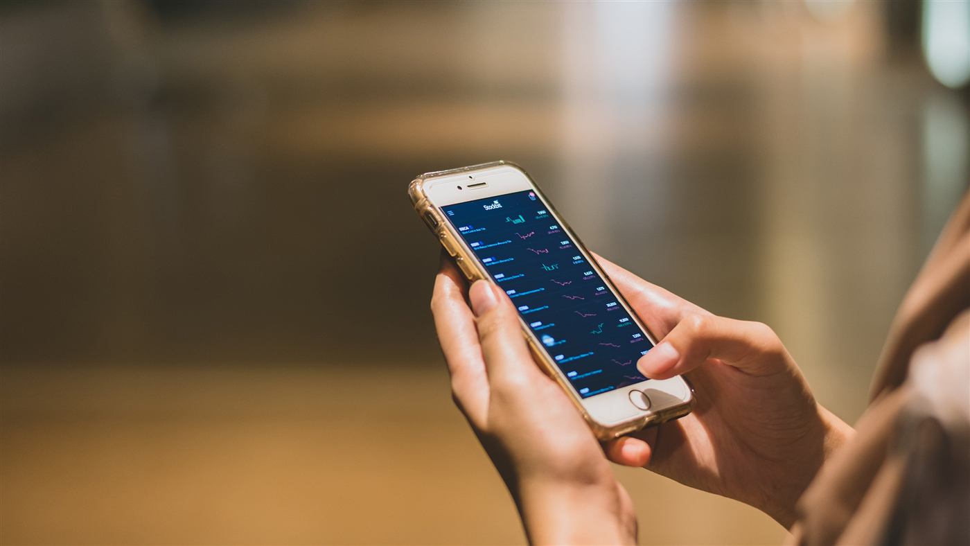 Persona revisando gráficas financieras en un teléfono celular